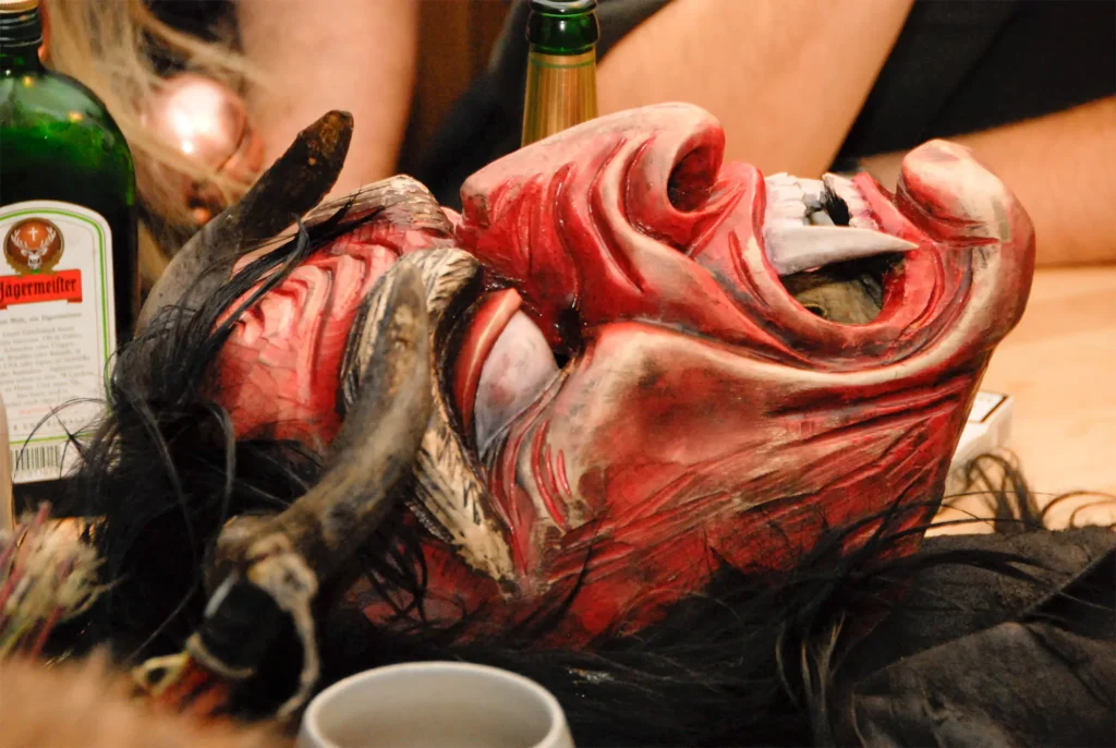 closeup of a red hand-carved wooden Krampus mask