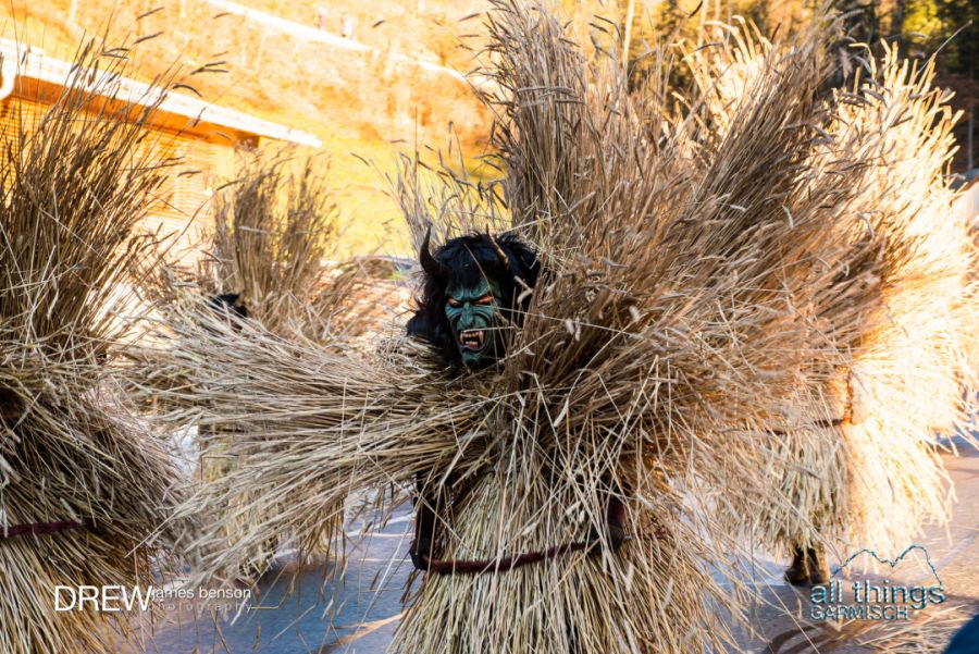 a Krampuslauf performer in Berchtesgaden, Germany dressed in straw and a green wooden mask